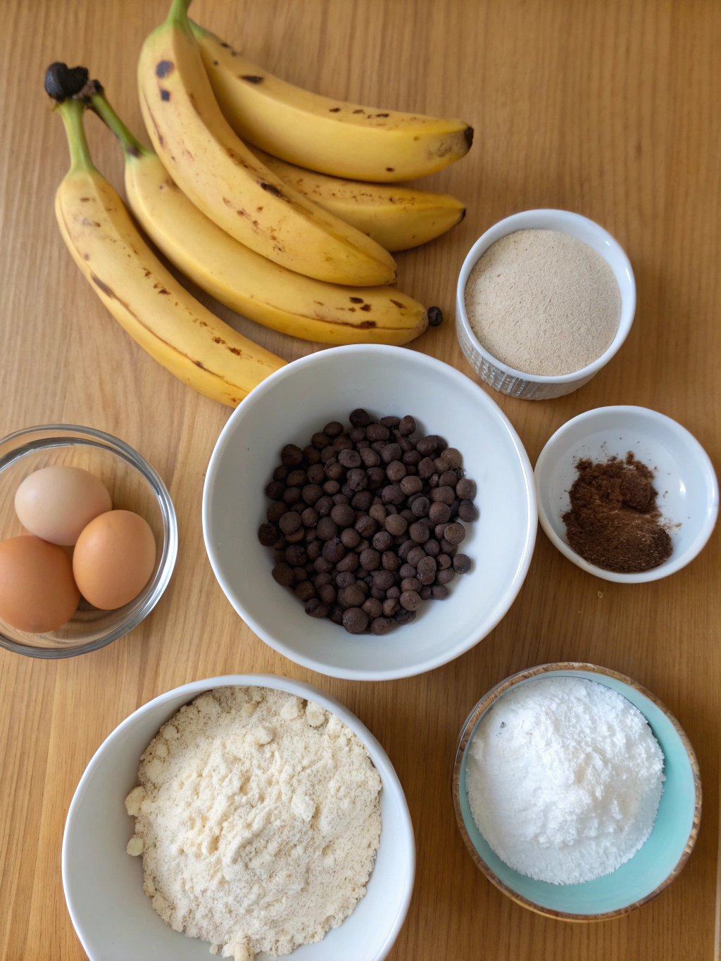Ingredients for Thermomix Banana Choc Chip Muffins laid out on a wooden surface