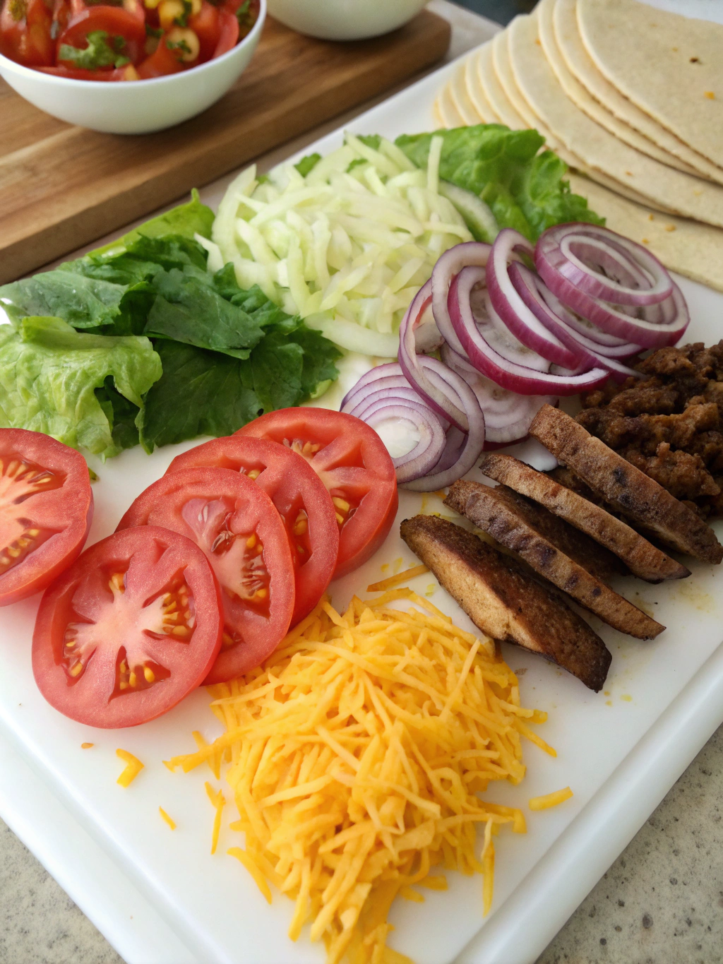 Taco ingredients laid out on a wooden cutting board